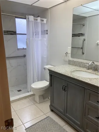 a bathroom with a granite countertop sink a toilet and shower