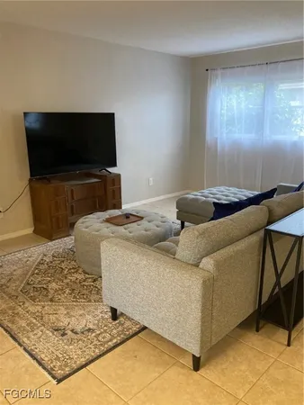 a living room with a bed and a flat screen tv