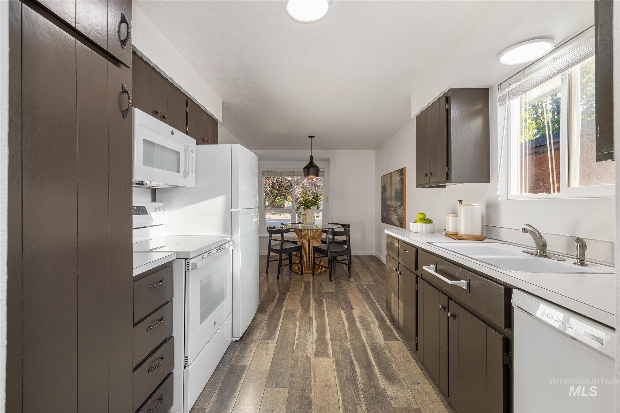 2302 Pendleton Street Boise, ID 83705 - Photo 15 of 35 Galley kitchen featuring dark wood-finish cabinetry, white appliances, and light countertops