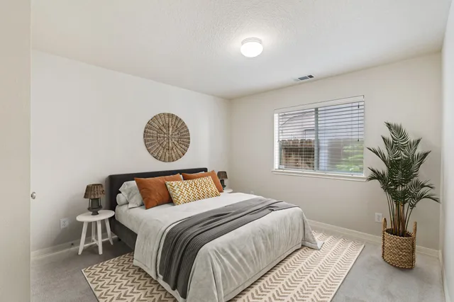 a bedroom with a bed and a potted plant