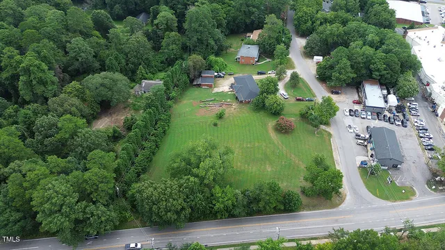 an aerial view of residential house with outdoor space and trees all around