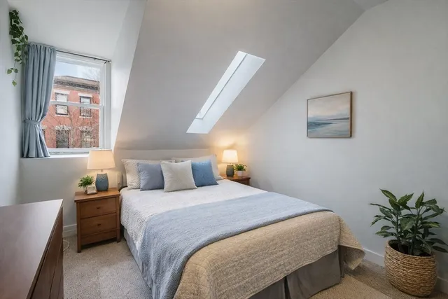 a bedroom with a large bed and a potted plant