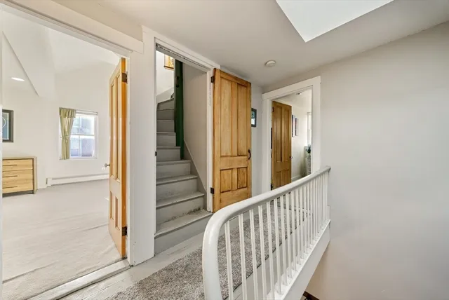 a view of a hallway with wooden floor and staircase
