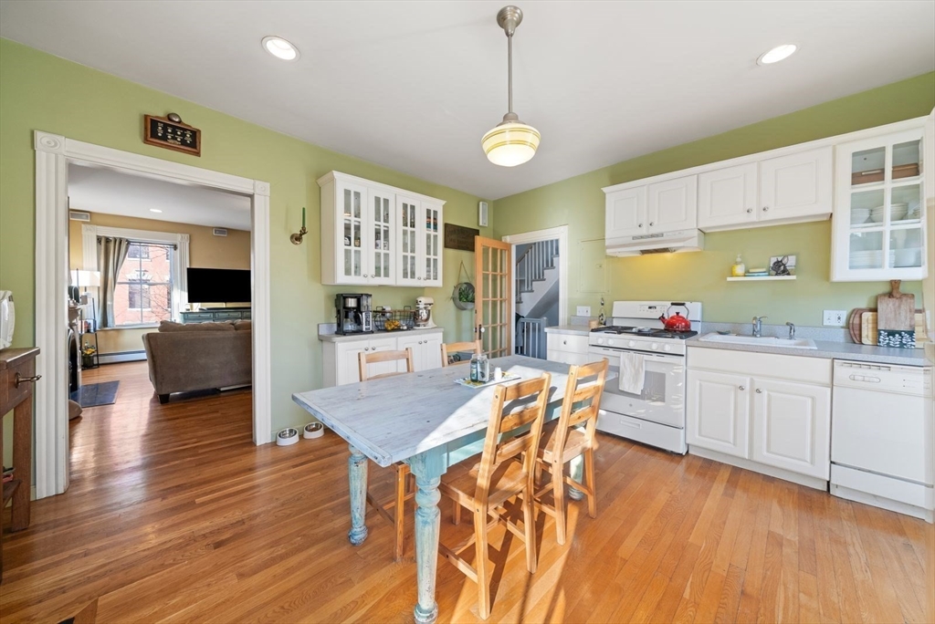 468 Shawmut Avenue, Unit 2 Boston, MA 02118 - Photo 7 of 30 a open kitchen with stainless steel appliances granite countertop a stove a sink dishwasher a dining table and chairs with wooden floor
