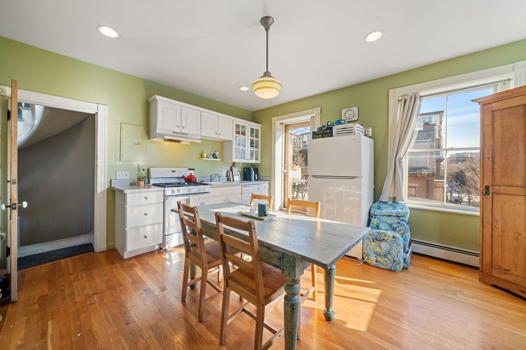 468 Shawmut Avenue, Unit 2 Boston, MA 02118 - Photo 9 of 30 a kitchen with stainless steel appliances granite countertop a stove a refrigerator a oven a sink with island chairs and wooden floor