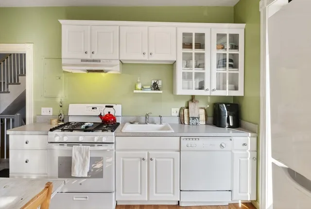 a kitchen with white cabinets and appliances