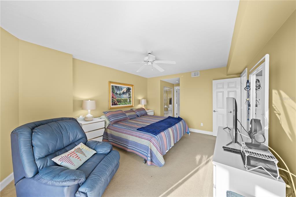 4575 South Atlantic Avenue, Unit 6209 Ponce Inlet, FL 32127 - Photo 26 of 53 a spacious bedroom with a bed and a chandelier