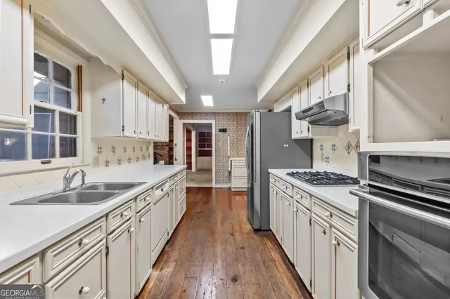 a kitchen with stainless steel appliances a sink stove and cabinets