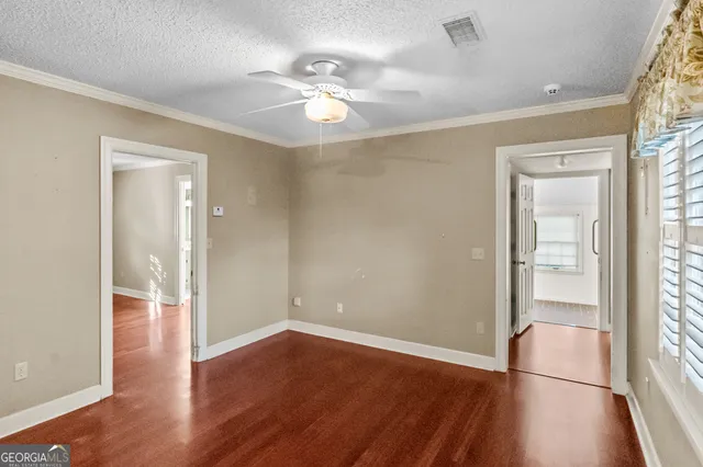 an empty room with closet and windows