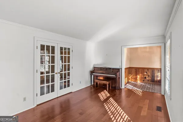 a view of a room with window wooden floor and front door