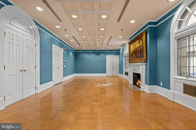 a view of an empty room with windows and fireplace