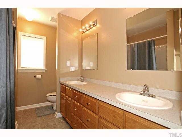 302 Graham Pond Road Angier, NC 27501 - Photo 11 of 12 a bathroom with a granite countertop sink a toilet and a mirror