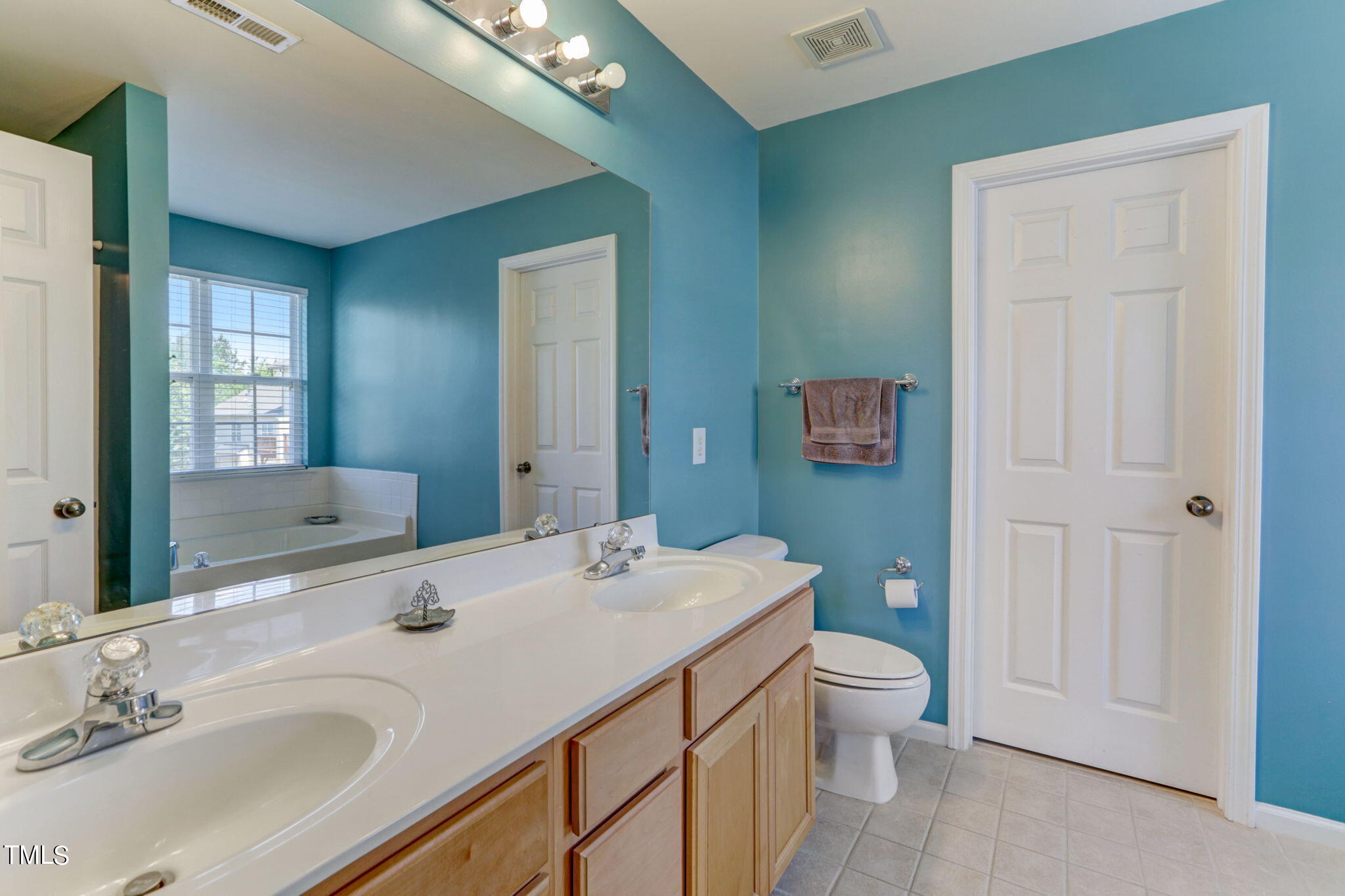 9802 Grettle Court Raleigh, NC 27617 - Photo 14 of 22 a bathroom with a sink a toilet and shower a mirror
