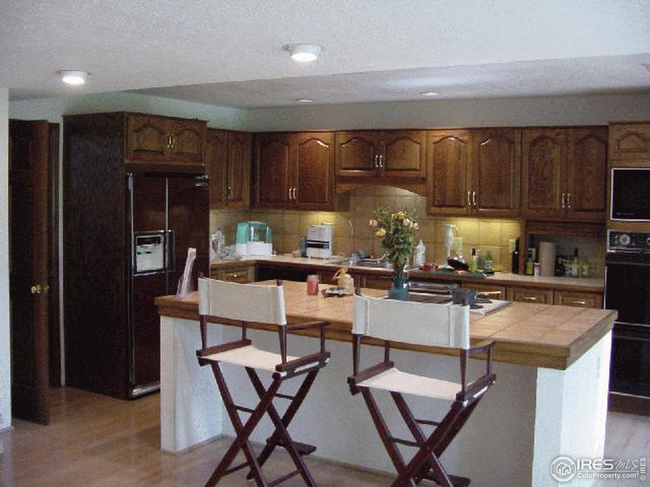 7130 Four Rivers Road Boulder, CO 80301 - Photo 7 of 10 a kitchen with a dining table chairs refrigerator and cabinets