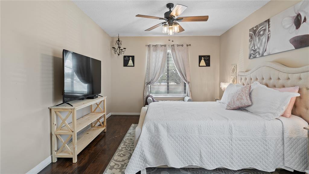 8203 Sun Spring Circle, Unit 12 Orlando, FL 32825 - Photo 28 of 38 a bedroom with a bed a flat screen tv and a chandelier