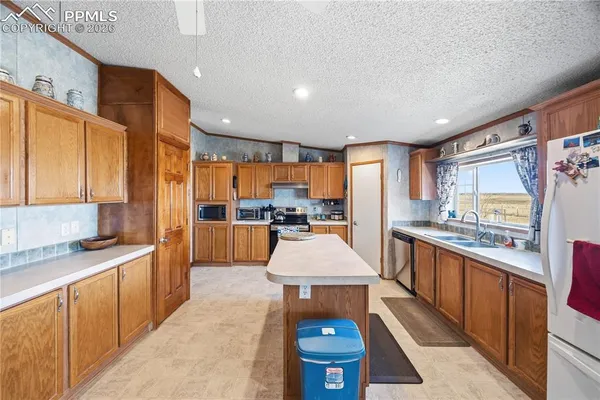 a large kitchen with kitchen island a sink stainless steel appliances and cabinets