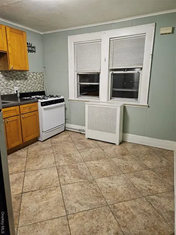 a living room with stainless steel appliances kitchen island granite countertop a stove a microwave and a sink