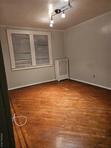 a view of an empty room with chandelier fan