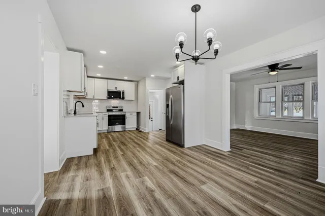 a view of a kitchen with stainless steel appliances granite countertop a refrigerator and a stove top oven