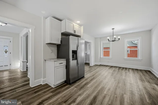 a view of a kitchen with refrigerator and wooden floor