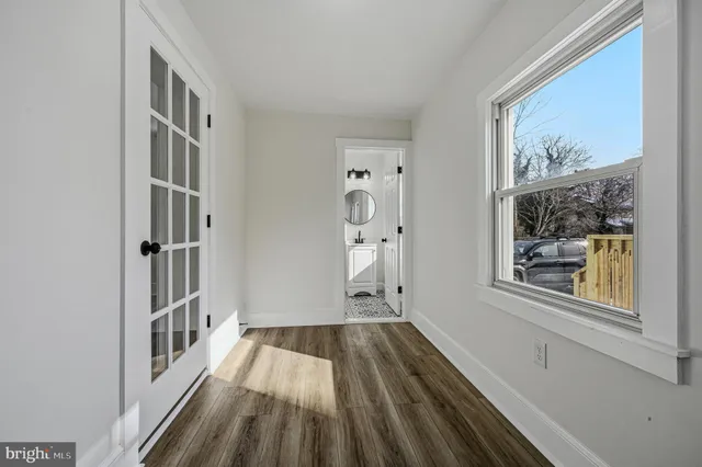 a view of a hallway with wooden floor and a window