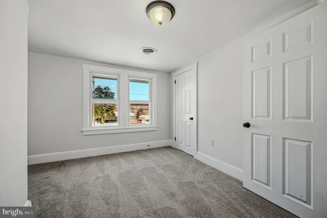 an empty room with windows and closet