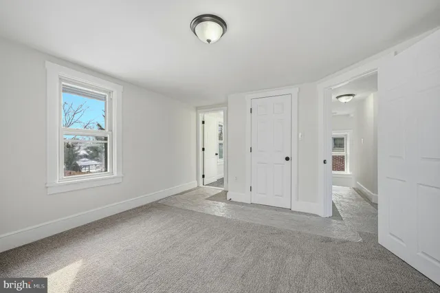 an empty room with windows and closet