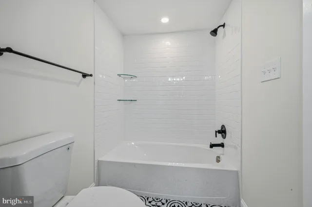 a bathroom with a shower a toilet and a tub