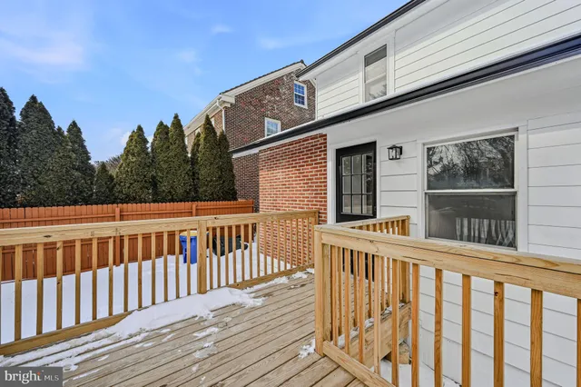 a view of a brick house with wooden floor and fence