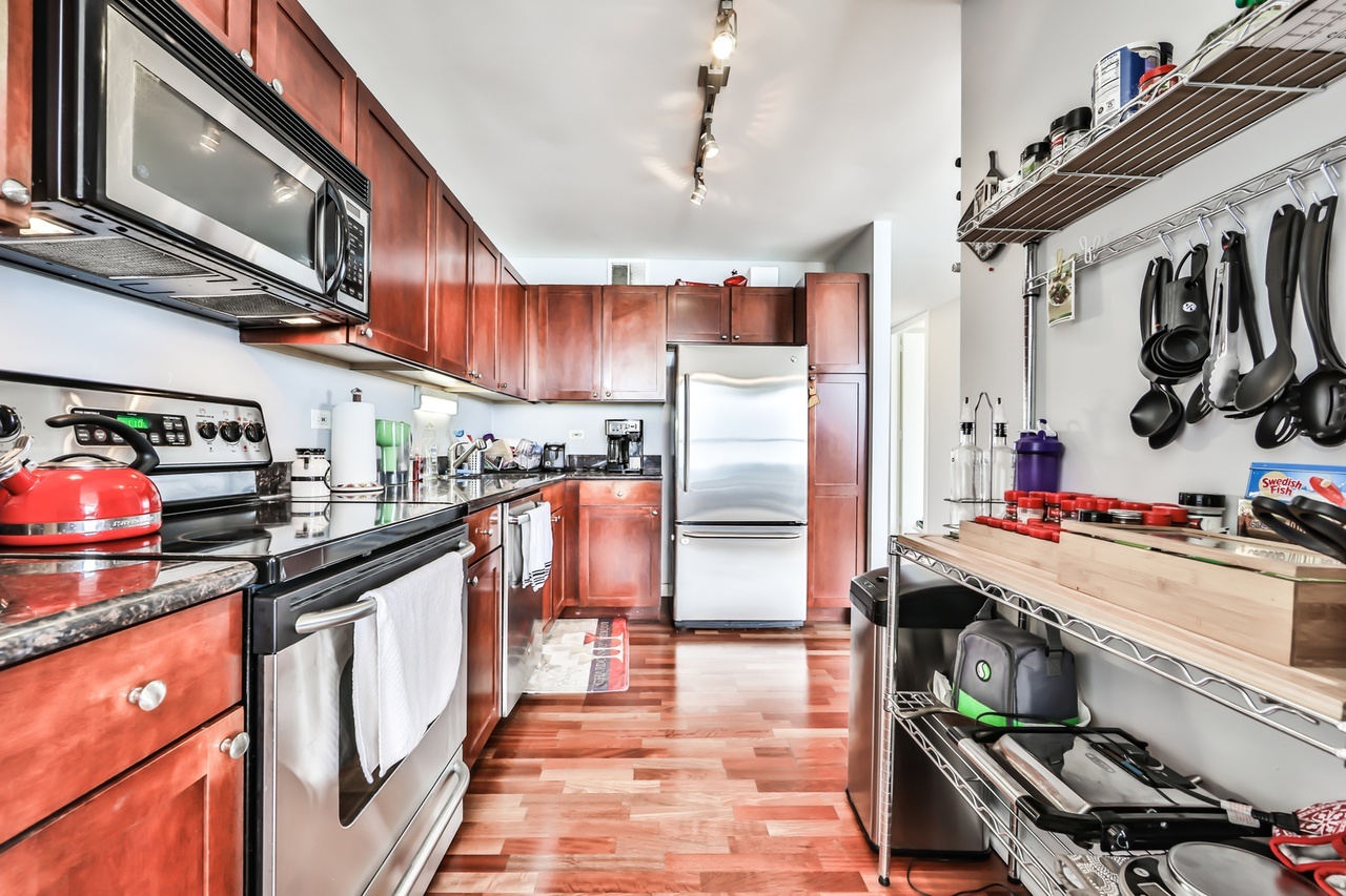 655 West Irving Park Road, Unit 3810 Chicago, IL 60613 - Photo 13 of 26 a kitchen with stainless steel appliances granite countertop a sink stove and refrigerator