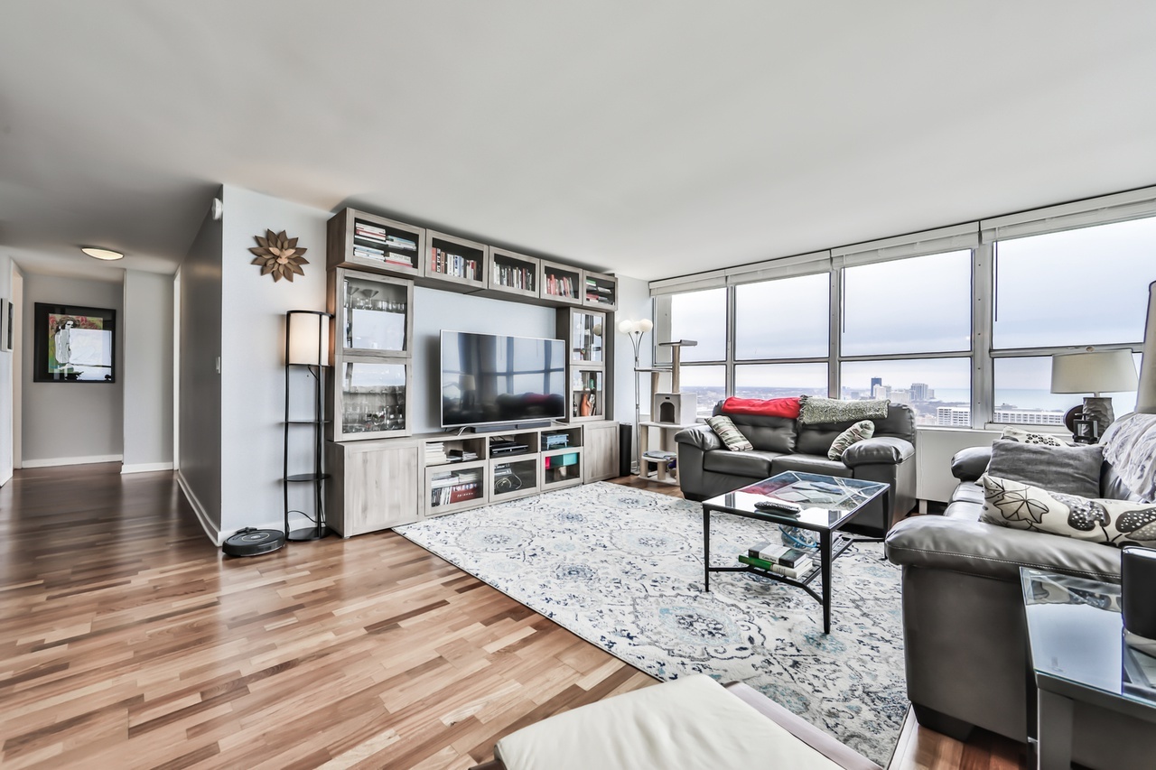 655 West Irving Park Road, Unit 3810 Chicago, IL 60613 - Photo 7 of 26 a living room with furniture and a flat screen tv