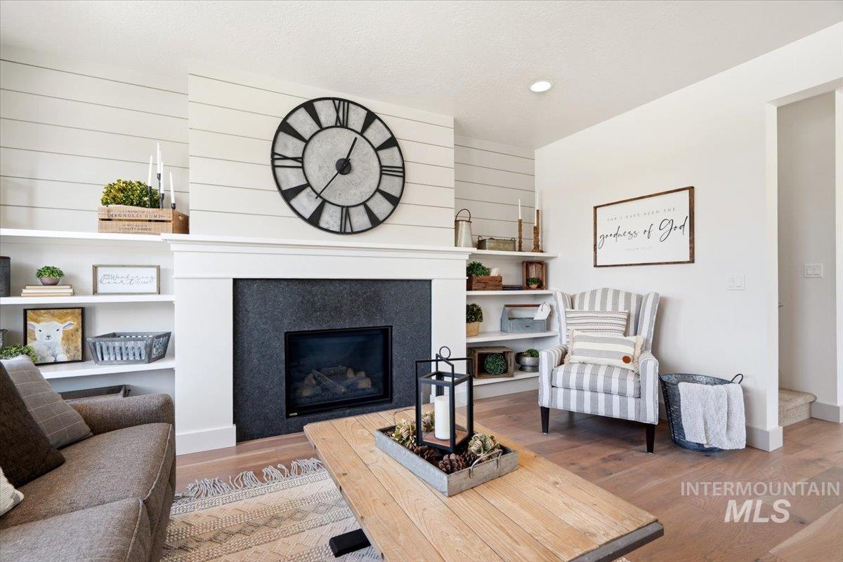 3794 South Single Tree Avenue Boise, ID 83716 - Photo 14 of 50 Fireplace wall featuring shiplap detailing, a gas fireplace with a dark stone surround, and a classic white mantel
