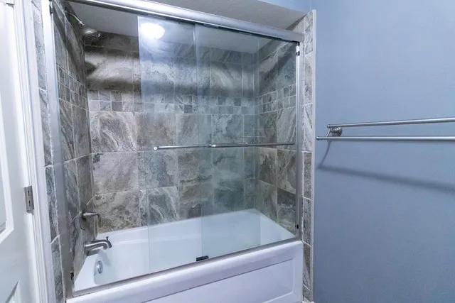 an empty room with windows and chandelier fan