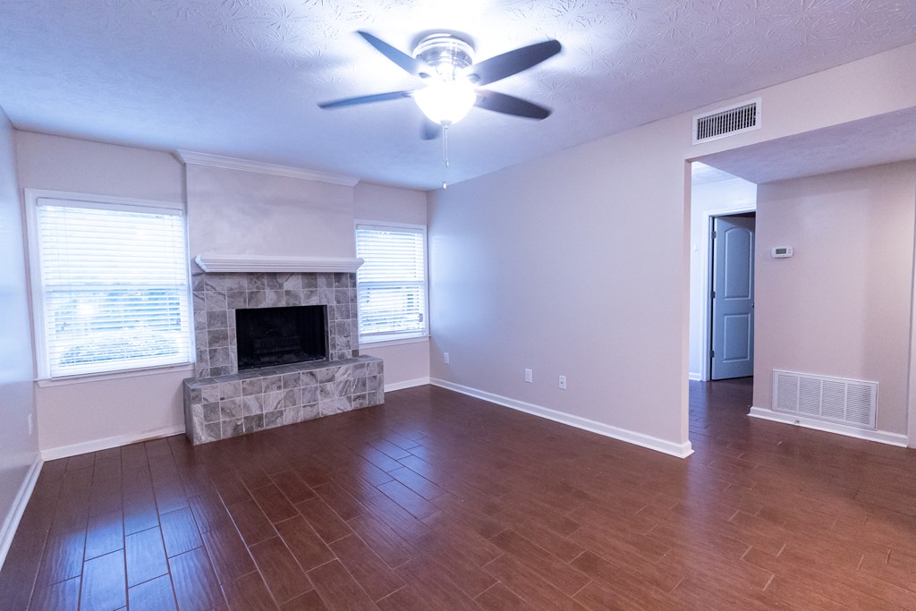 2525 Norris Road, Unit 36 Columbus, GA 31907 - Photo 2 of 28 an empty room with windows a fireplace a ceiling fan and wooden floor