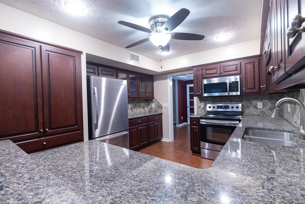 2525 Norris Road, Unit 36 Columbus, GA 31907 - Photo 5 of 28 a kitchen with stainless steel appliances granite countertop a refrigerator a stove a sink and a microwave oven