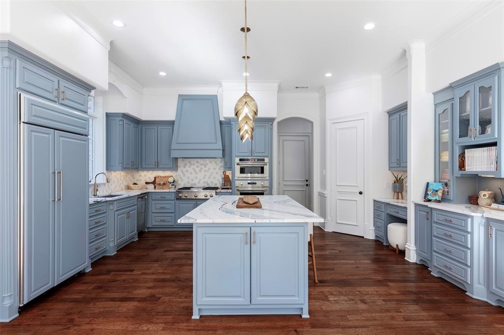 6401 St Michael Drive McKinney, TX 75072 - Photo 11 of 34 a large kitchen with stainless steel appliances a large center island and a wooden floors