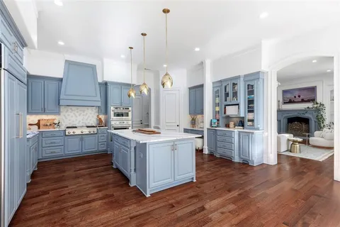 a large kitchen with granite countertop a large counter top space a sink stainless steel appliances and cabinets