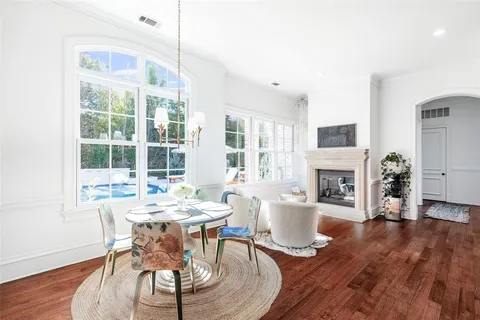 a dining room with furniture a fireplace and wooden floor