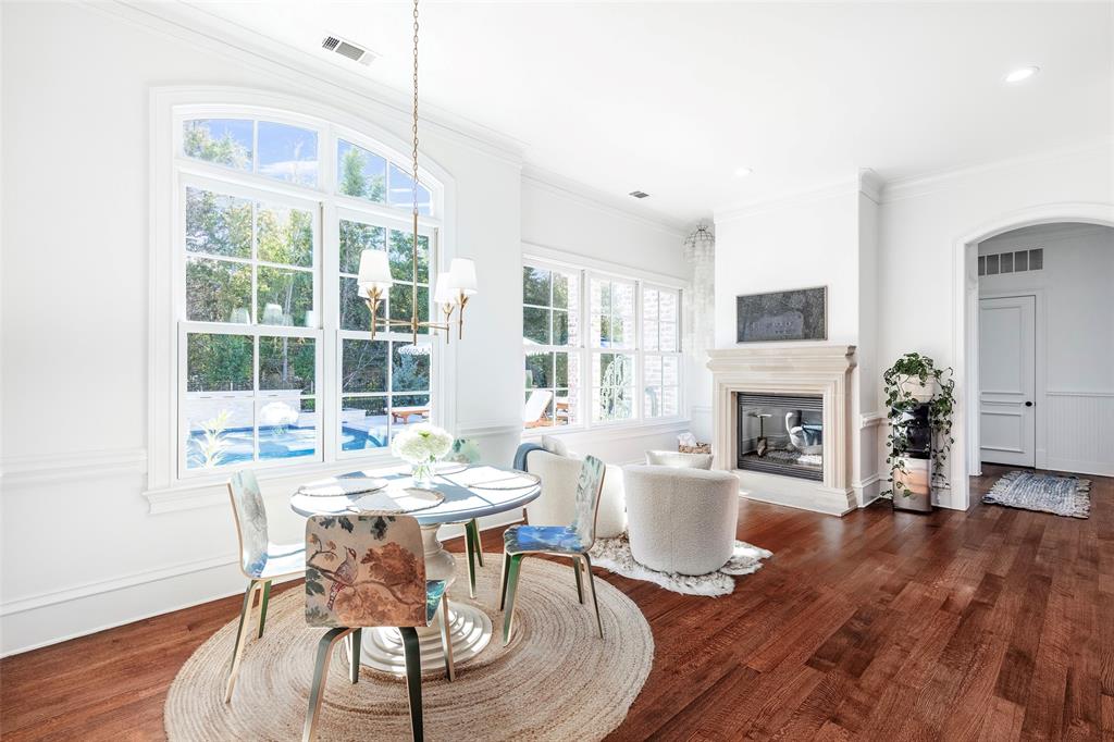 6401 St Michael Drive McKinney, TX 75072 - Photo 15 of 34 a dining room with furniture a fireplace and wooden floor