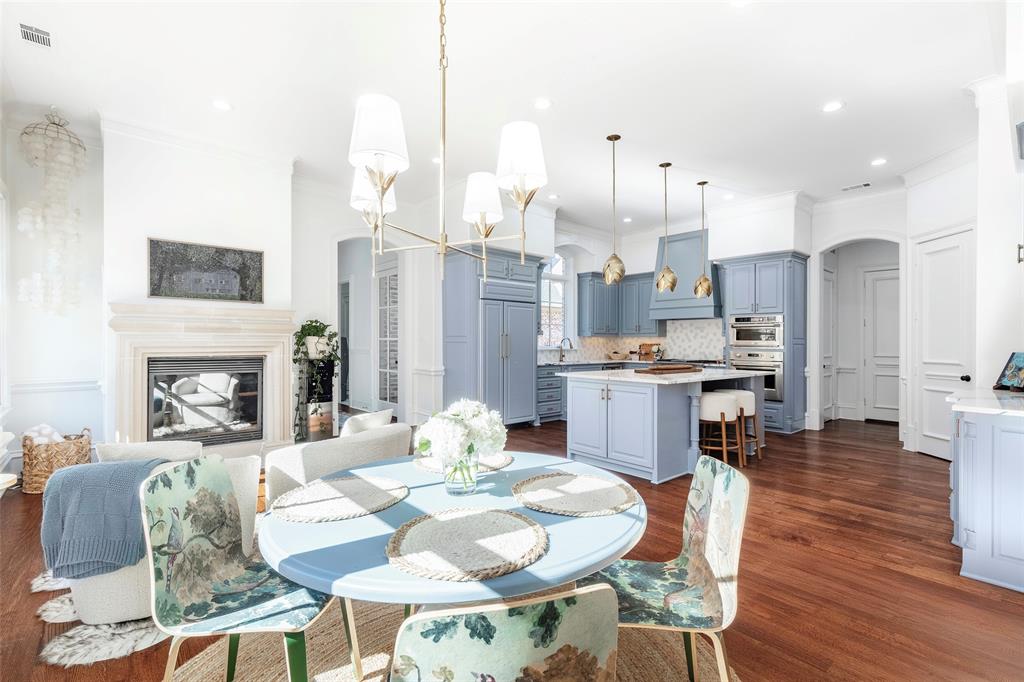 6401 St Michael Drive McKinney, TX 75072 - Photo 16 of 34 a view of a dining room with furniture a fireplace and wooden floor