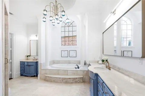 a spacious bathroom with a tub sink and mirror