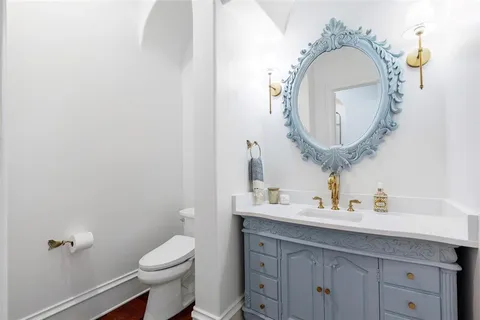 a bathroom with a toilet a sink and a mirror