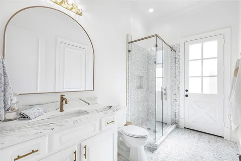 a bathroom with a double vanity sink toilet and shower