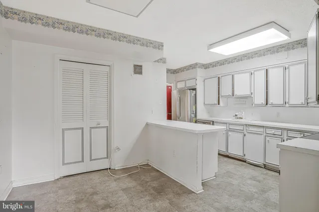 a large white kitchen with cabinets