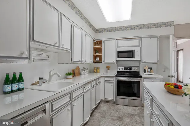 a kitchen with stainless steel appliances granite countertop a sink stove and white cabinets