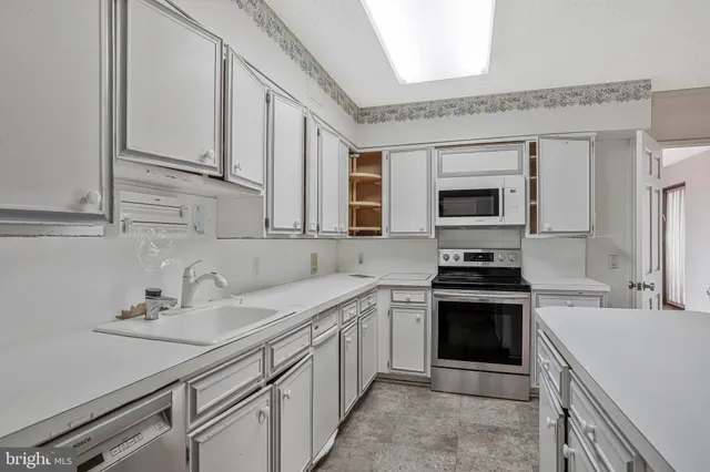 a kitchen with a sink stove and microwave
