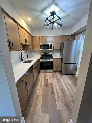 a kitchen with a sink stainless steel appliances a counter space and cabinets