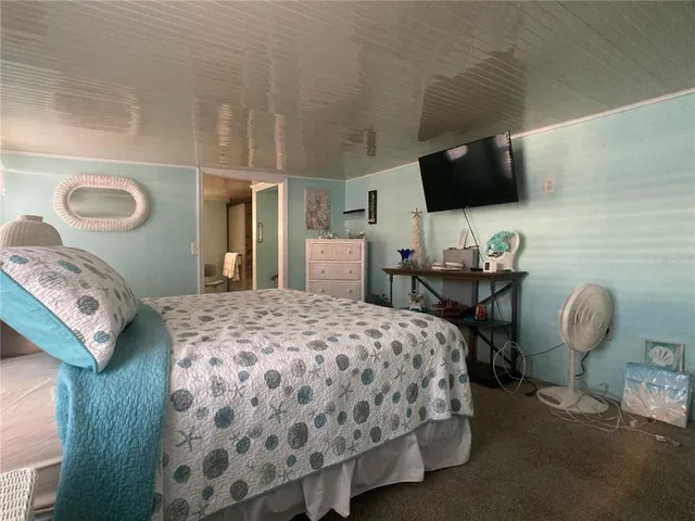 a bedroom with a bed and flat screen tv