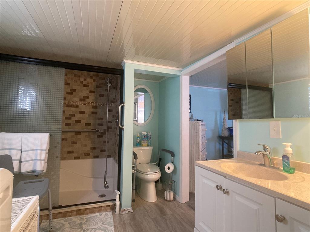 1710 7th Street Southwest, Unit 27 Ruskin, FL 33570 - Photo 16 of 26 a bathroom with a granite countertop sink a toilet a mirror and shower