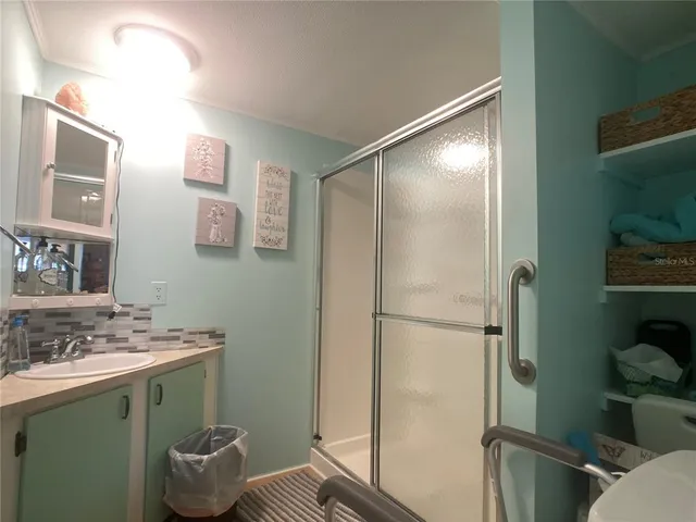 a bathroom with a granite countertop sink toilet and shower